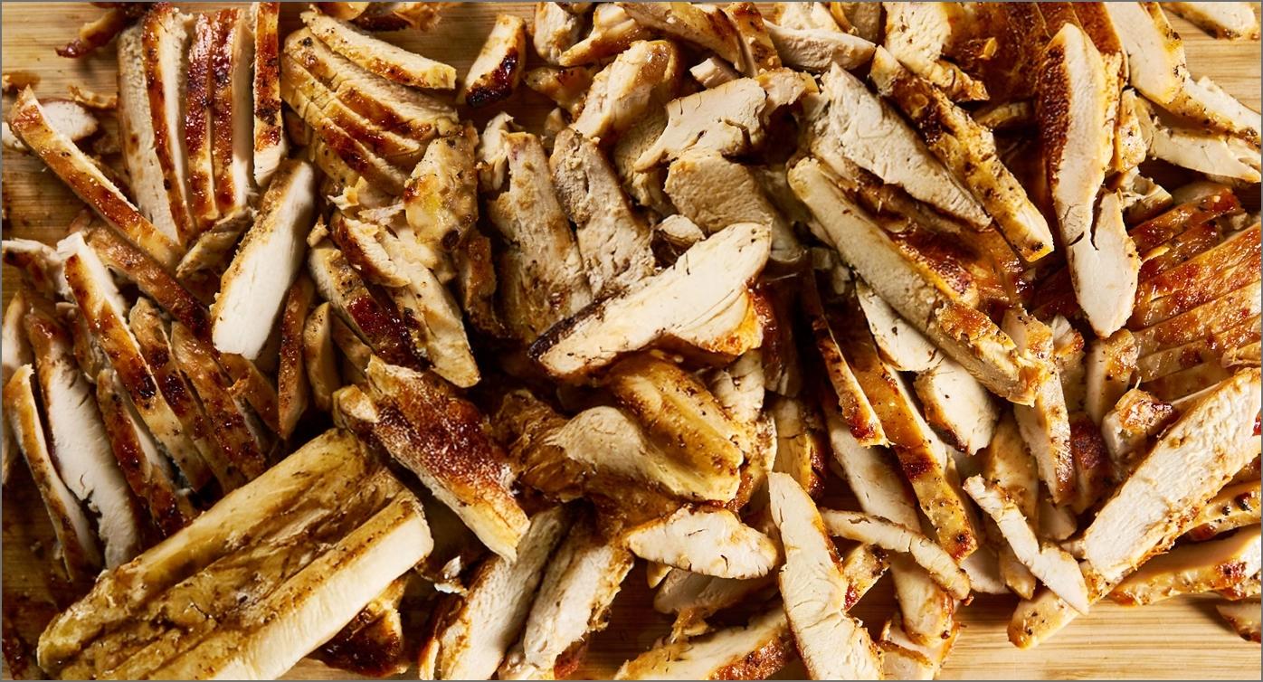 Preparación de las fajitas con la pechuga de pollo Avigrupo cortada sobre una tabla de madera